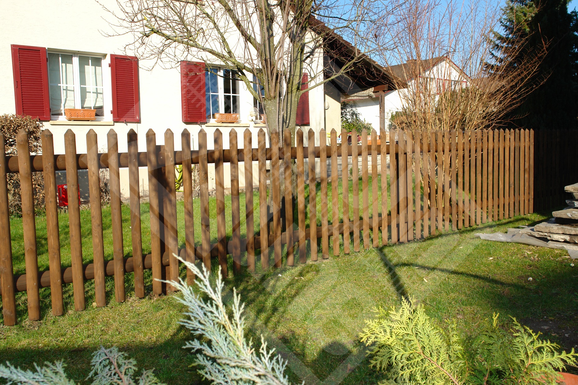 2 Palisadenzaun mit Holzpfosten und Halbrundtraversen lasiert hellbraun