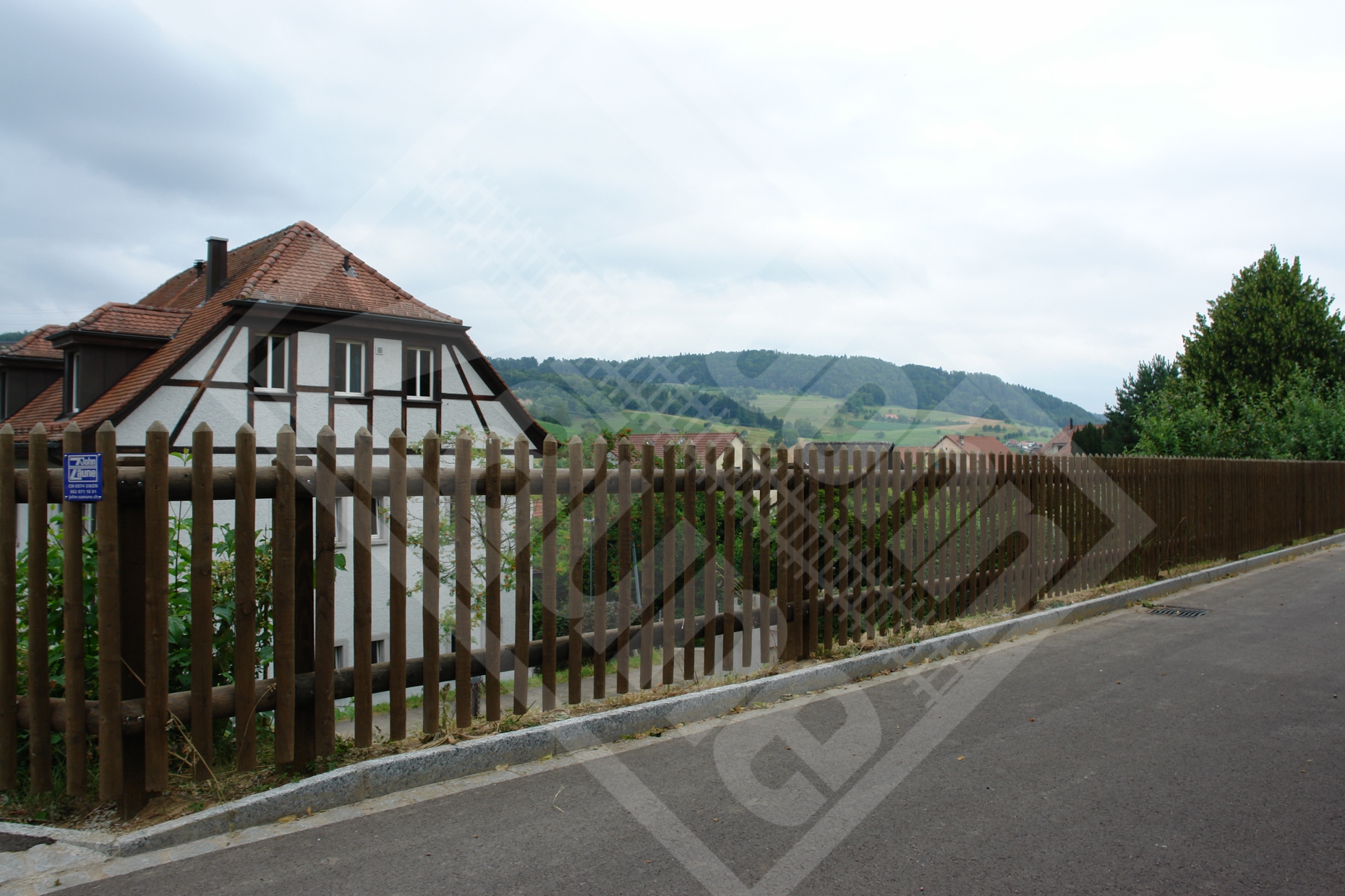 3 Palisadenzaun mit Vierkantholzpfosten und Halbrundholztraversen lasiert mittelbraun