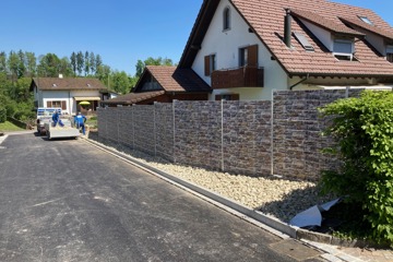 Letzte Arbeiten am Doppelstab-Gittermattenzaun mit PVC-Streifen – Montage und Bodenbearbeitung durch Monteure