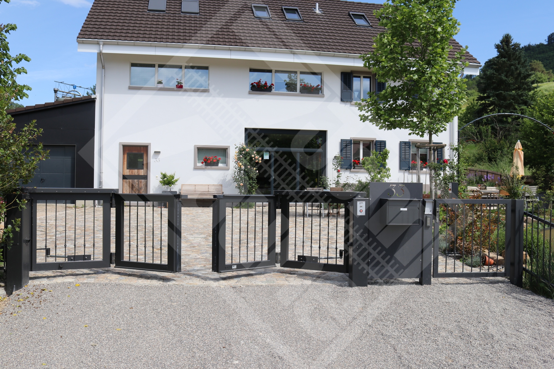1 Automatisches Faltflügeltor und Personentüre mit Schmuckstab-Füllung