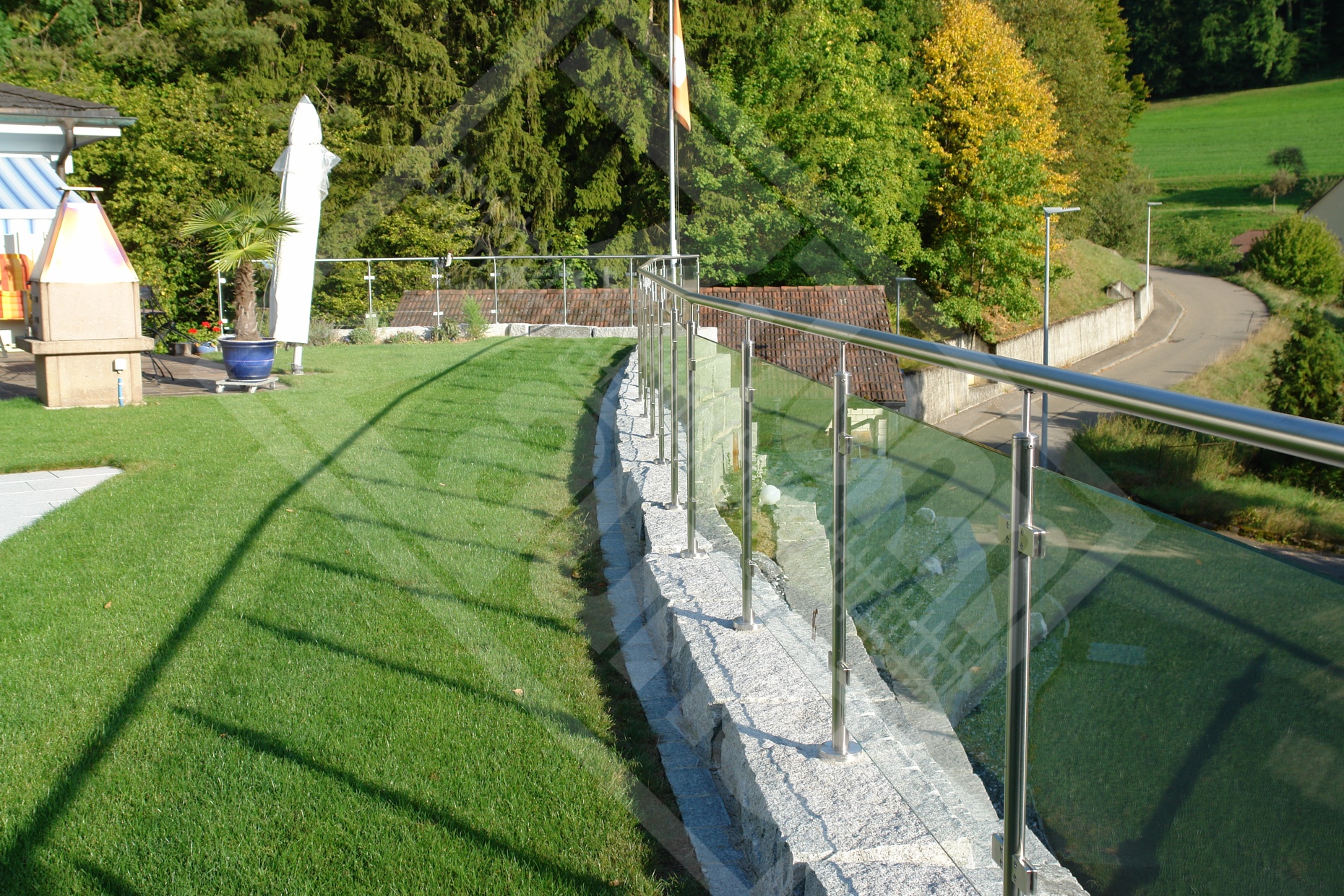 1 Klarglasgeländer mit Handlauf auf Granitsteinmauer