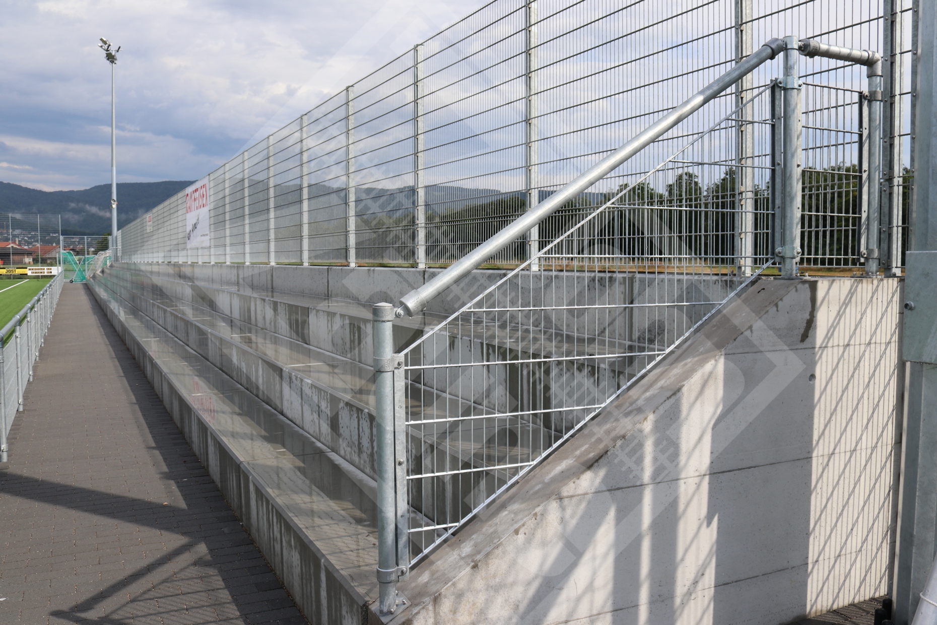 5 Zuschauerabschrankung mit Handlauf und Gittermatten entlang der Treppe